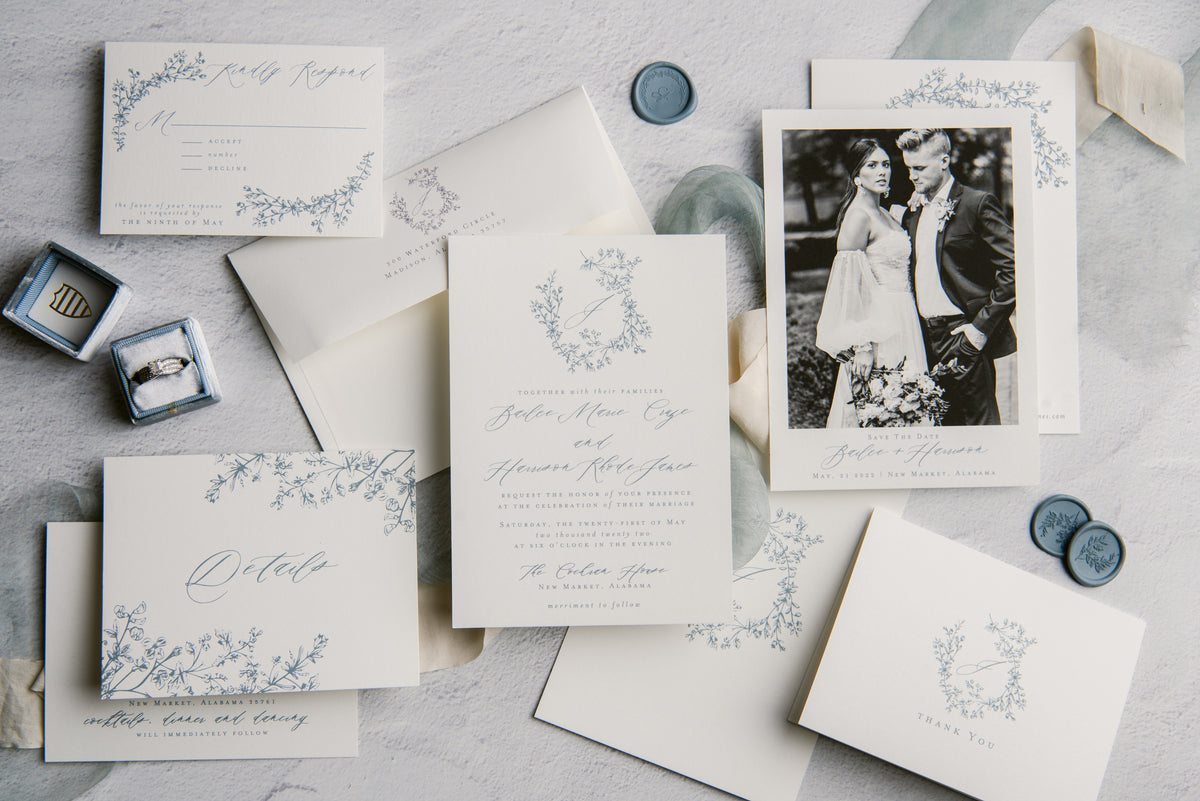 Wedding invitation set with floral designs on a light gray surface